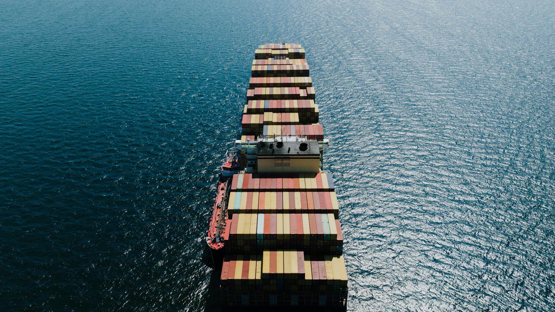 Drone shot of a loaded container ship sailing through the sea near Naples, Italy.